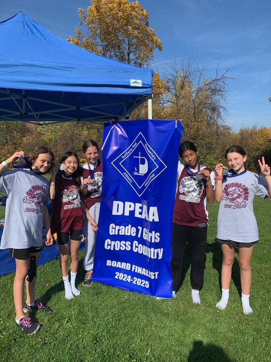 Picture of the Cross Country team holding a banner